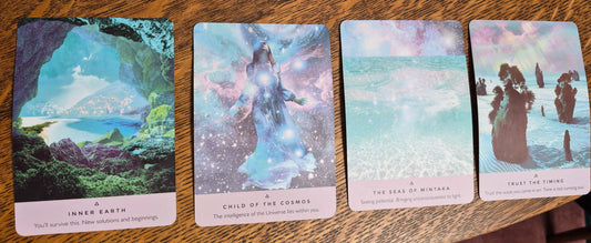 Four oracle cards on a wooden table: Inner Earth, Child of the Cosmos, The Seas of Mintaka, and Trust the Timing.