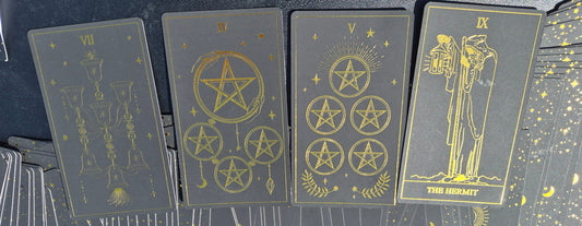 Four tarot cards laid out for the May 18 2026 daily collective reading: 7 of Cups, 4 of Pentacles, 5 of Pentacles, and The Hermit
