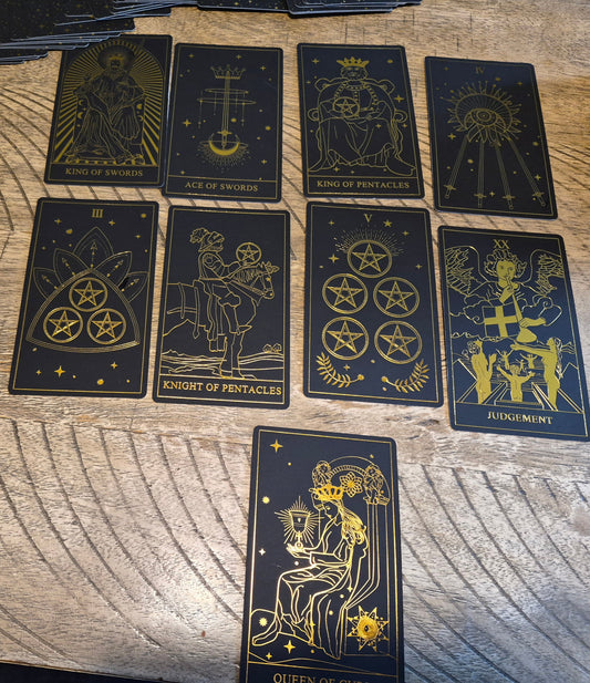 Daily tarot card spread featuring King of Swords, Ace of Swords, King of Pentacles, Judgement, Queen of Cups and more on a dark wood surface