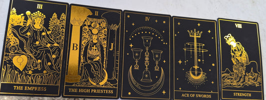 Five gold-on-black tarot cards: The Empress, The High Priestess, Four of Cups, Ace of Swords, and Strength.